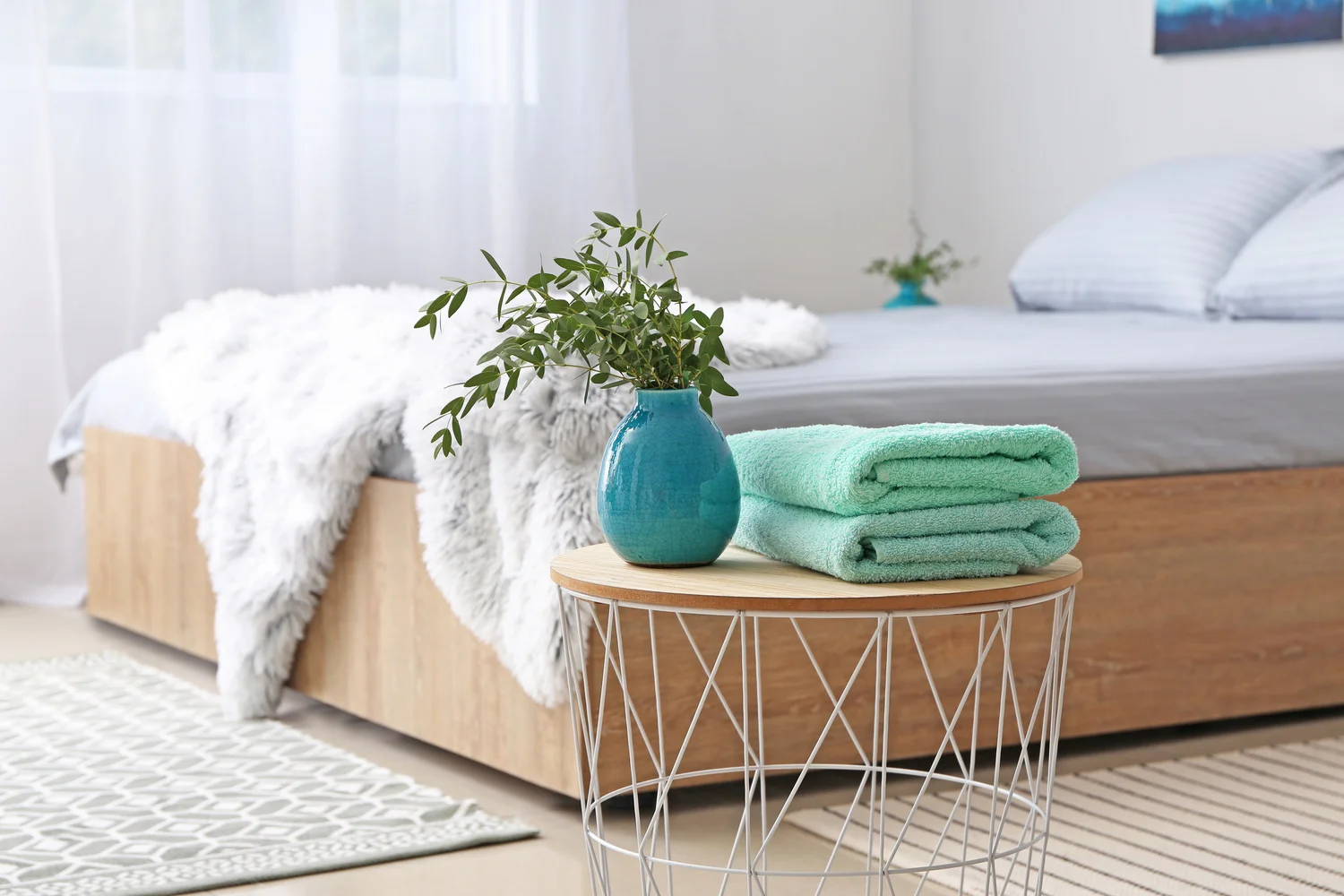 Stack of clean towels on table in bedroom